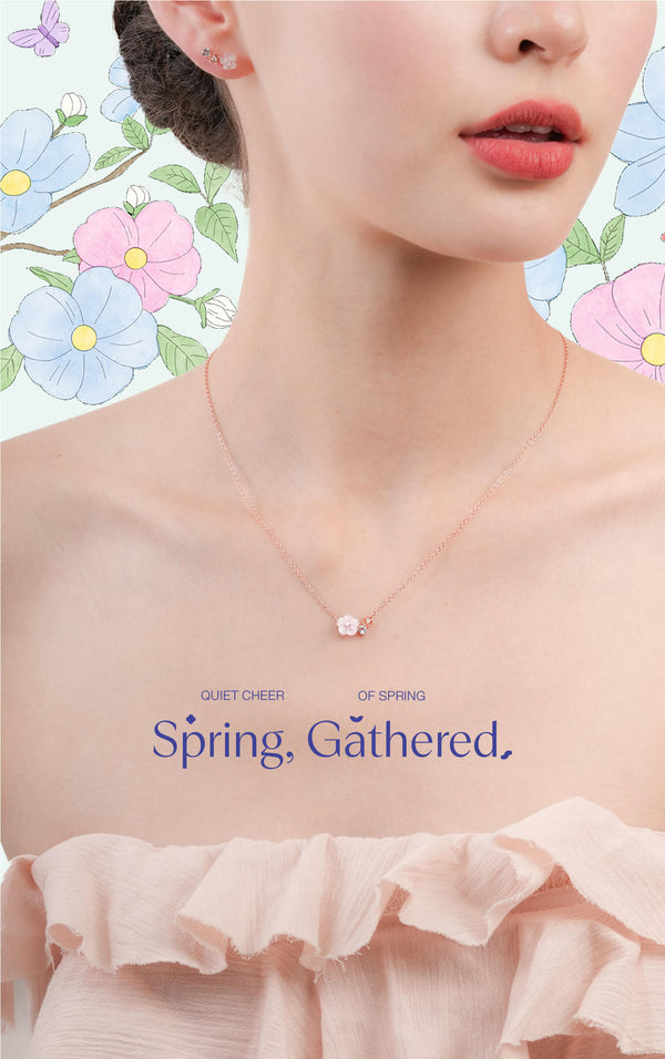 Woman wearing a delicate flower cluster necklace with a floral background and 'Spring Gathered' overlay text.
