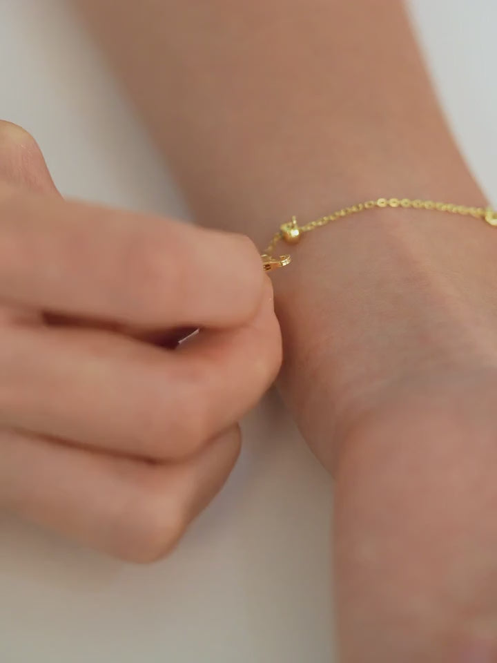 Step-by-step video of a person putting on an adjustable bracelet, fastening it securely and adjusting it to fit their wrist.